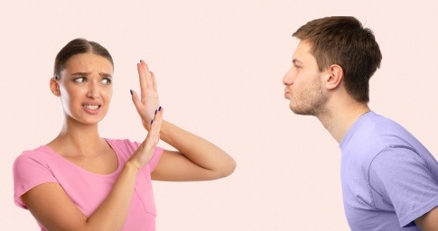Ein Mann will eine Frau küssen, die ihm ihre Abneigung offen demonstriert