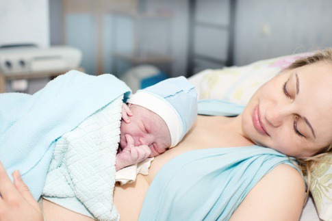 Ein Baby liegt bei einer Frau auf der Brust nach Schwangerschaft