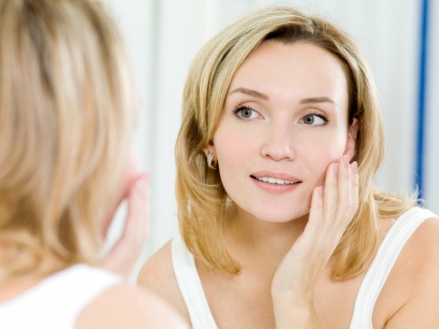 Eine Frau gibt Gesichtpflege mit dem Coenzym Q10 ins Gesicht