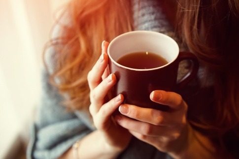 Frau hält Teetasse in Händen als Zeichen für Fasten