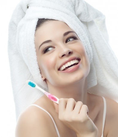 Eine Frau zeigt ihre Zähne, die Hautprobleme verursachen können