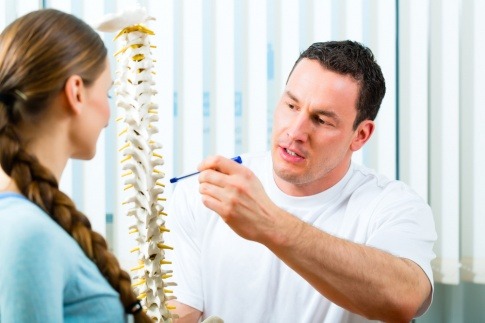 Ein Arzt zeigt anhand eines Skelettes die Funktionen und den Aufbau der Wirbelsäule