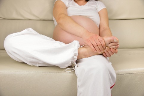 schwangere Frau mit schmerzenden Beinen