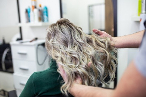 Eine Frau bekommt den Haarfarbentrend Grey Blending