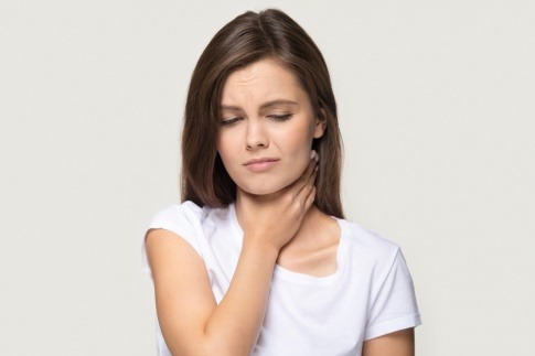 Eine Frau hält den Hals wegen Halsschmerzen und benötigt Ingwer