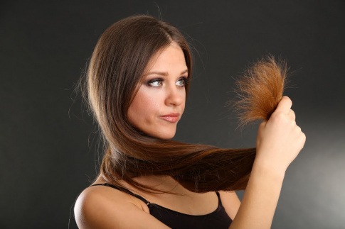 Frau mit langen kaputten Haaren vor dem Reparieren