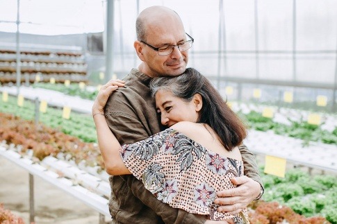 Ein Mann und eine Frau in der Midlife Crisis umarmen sich