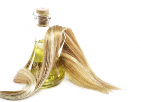 Haare sind um eine Flasche Olivenöl gelegt