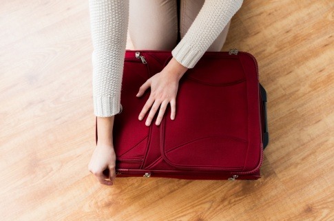 Frau packt Koffer, eventuell für Wellness-Urlaub