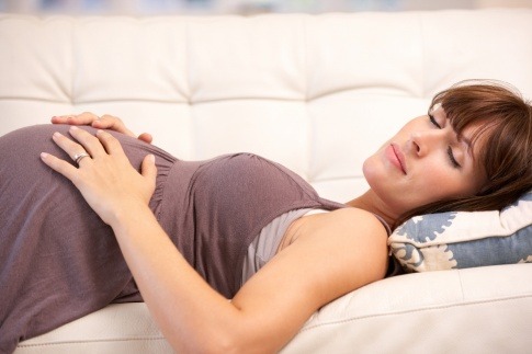 Eine schwangere Frau schläft auf dem Rücken.