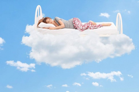 Frau im Bett auf Wolken