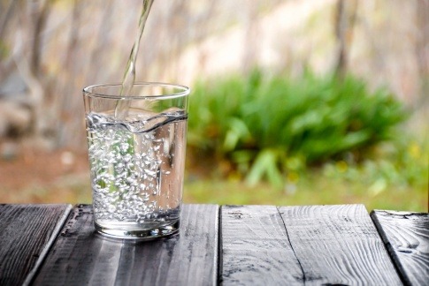 Lebendig wirkendes Wasser fließt in ein Glas