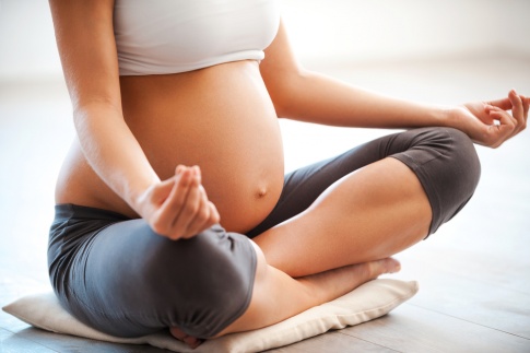 Eine schwangere Frau macht Yoga für Schwangere