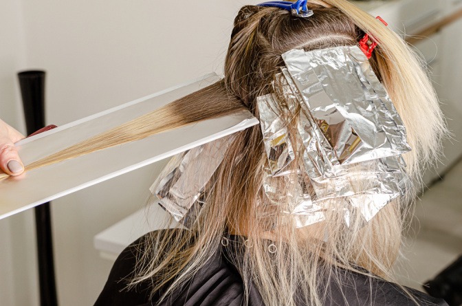 Frau beim Färben der Haare mittels Airtouch Balayage