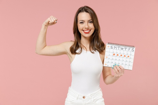 Frau mit Menstruationskalender zeigt ihre Kraft