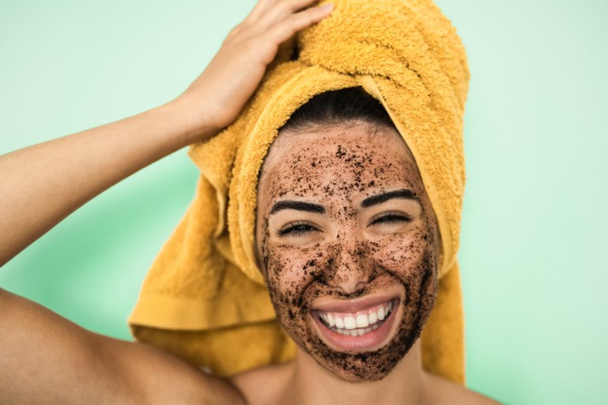 Frau mit Kaffeepeeling im Gesicht