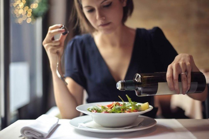 Eine Frau isst Salat, damit sie vom Mittagstief verschont bleibt