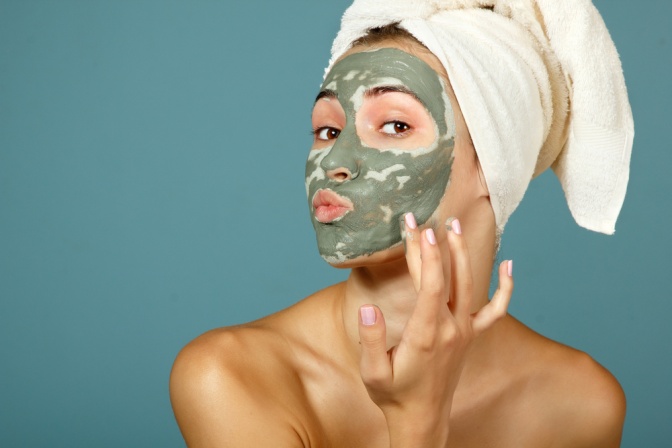 Frau mit Gesichtsmaske gegen unreine Haut