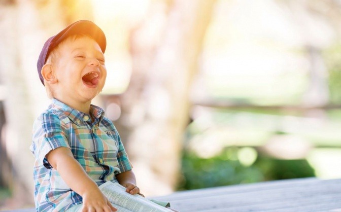 Ein kleines Kind mit abstehenden Ohren lacht