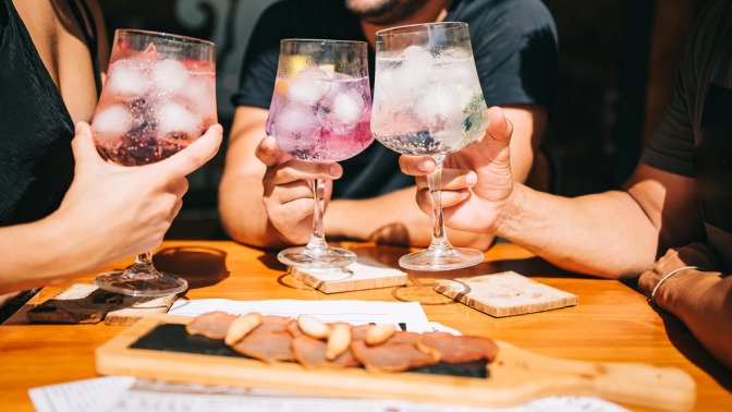 Drei Freunde stoßen mit alkoholfreien Cocktails an.