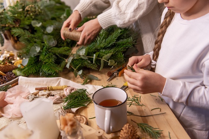 Mutter und Tochter basteln einen Adventskranz
