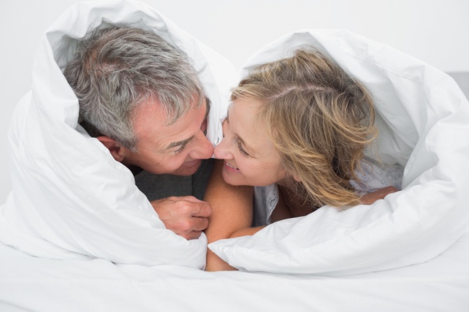 Ein älteres Paar liegt im Bett
