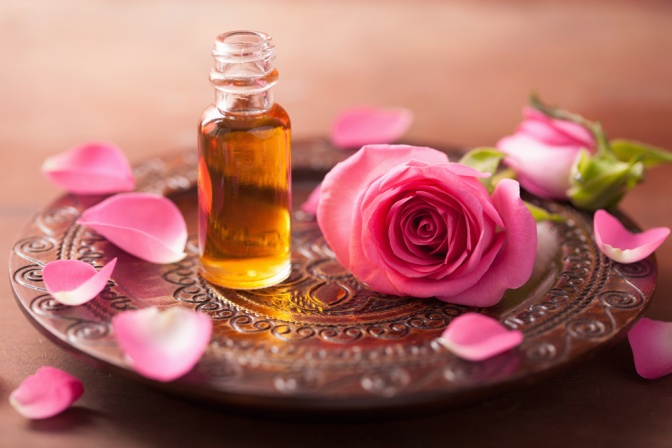 Ein Fläschchen ätherisches Öl und Rosen