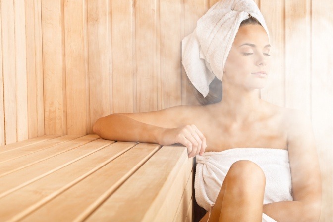 Eine Frau genießt den Duft von ätherischem Öl in der Sauna