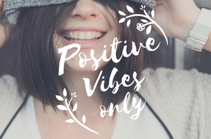 Lachende Frau mit Botschaft: Positive Vibes only.