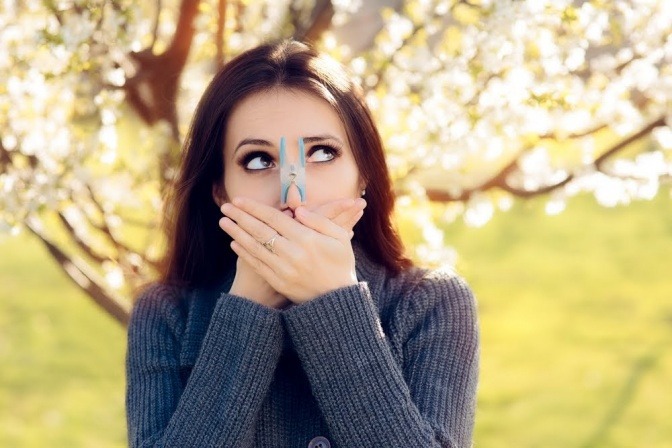 Eine Frau hat wegen einer Allergie eine Klammer auf der Nase
