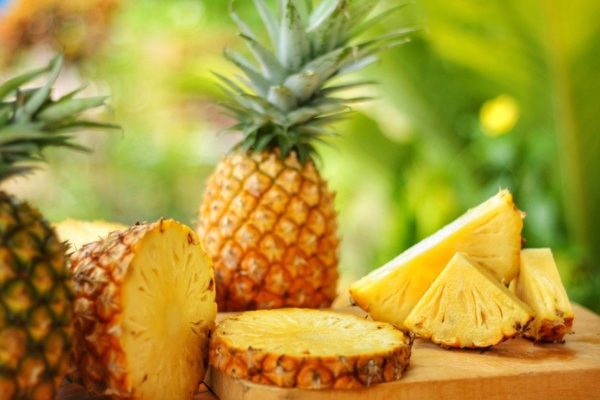 Ananas ganz und aufgeschnitten.