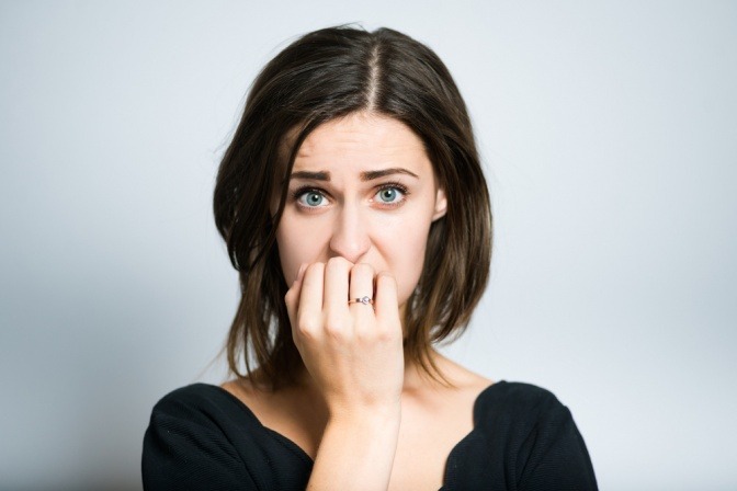 Frau mit nervösem Gesichtsausdruck hat Angst vor etwas.