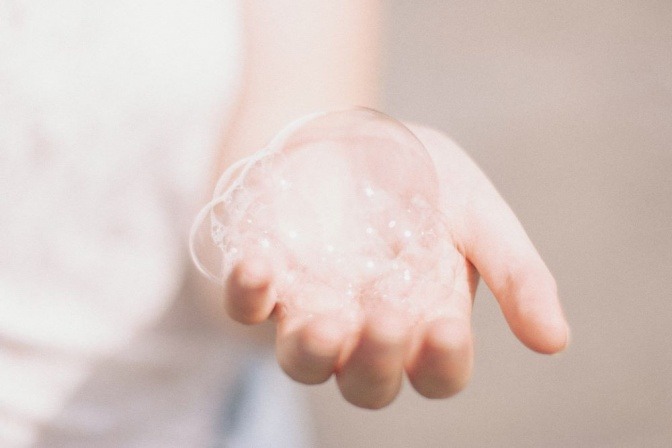 In einer Hand ist festes Shampoo aufgeschäumt, um es anzuwenden
