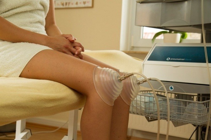 Ein Knie mit Arthrose wird mit Pulsationsmassage behandelt