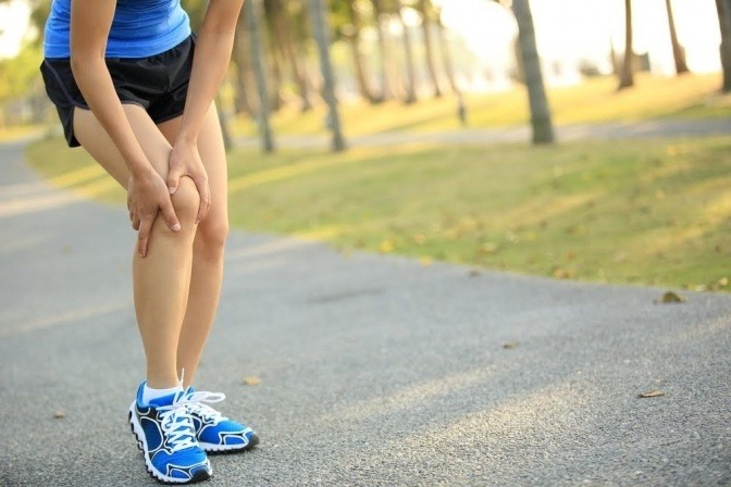 Eine Läuferin greift auf Knie mit Arthrose