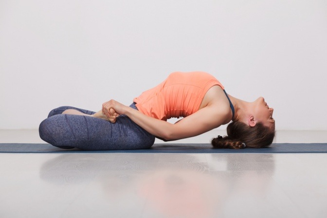 Eine Frau führt eine Asana (Bewegungsübung) aus