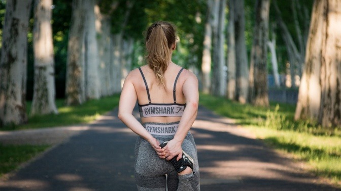 Eine Frau wärmt sich vor dem Joggen auf