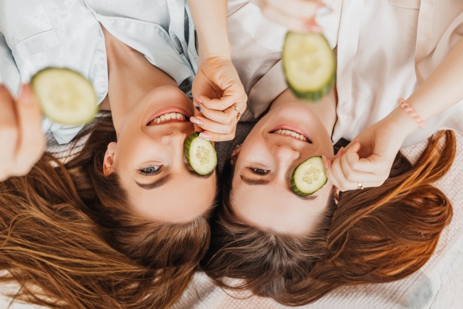 Zwei Frauen mit Gurkenscheiben gegen Augenringe auf den Augen