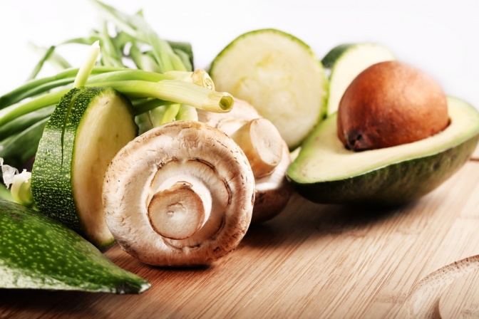 Avocados und Pilze auf einem Brett