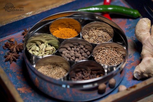Ein ayurvedisches Gericht und Gewürze im Löffel