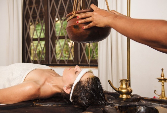 Eine Frau bekommt einen Ayurveda Stirnguss
