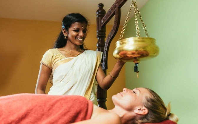 Eine Frau führt eine Ayurvedabehandlung durch