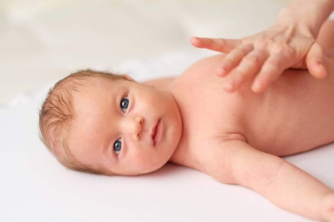 Ein Baby wird massiert