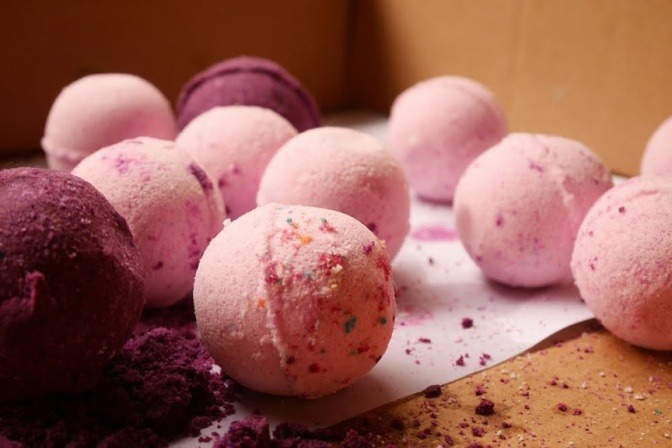 Es liegen viele Badekugeln in Pink- und Violett-Tönen nebeneinander