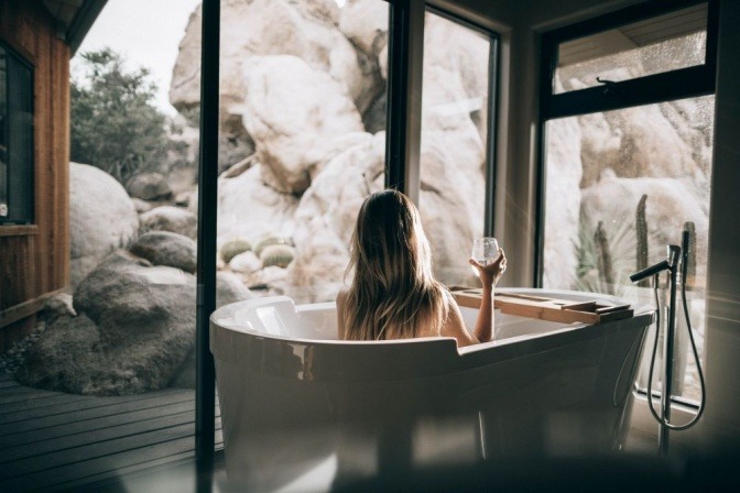 Eine Frau sitzt in einer Badewanne und genießt