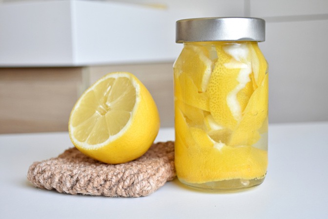 Zitronenschalen und Essig in einem Glas