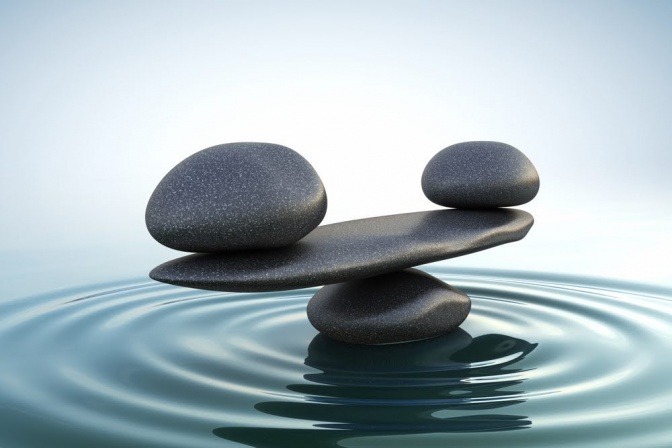 Steine sind im Wasser übereinander gestapelt als Zeichen für Balance