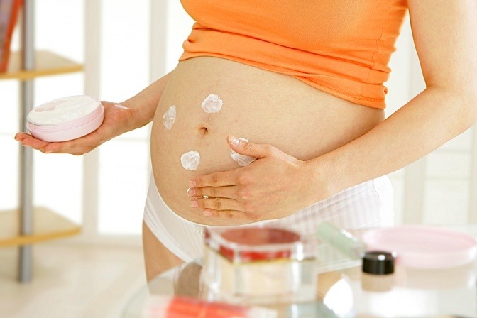 Frau bei der Bauchpflege in der Schwangerschaft