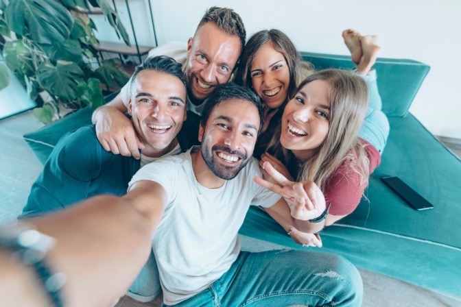 Eine Gruppe von Freunden umarmt sich und macht einen Selfie.