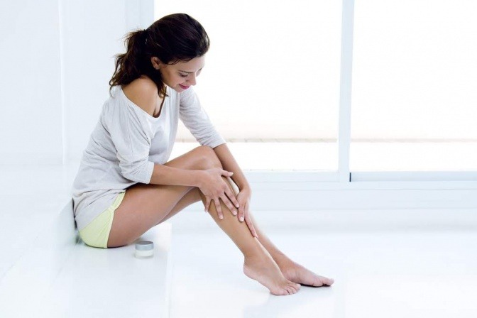 Eine Frau pflegt ihre glatten Beine nach dem Epilieren